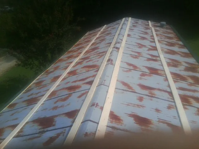 Rusted metal roof panels with new wood purlins before replacement — Storm Damage Roof Repair in Verdi by Roofing Brothers