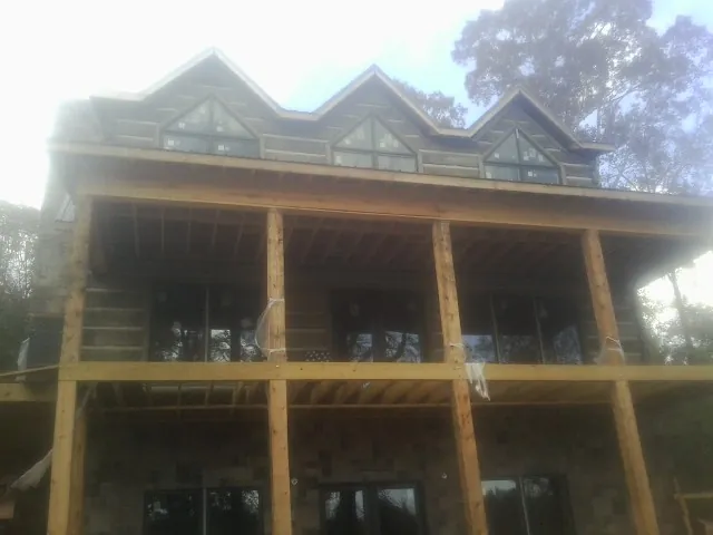 Dormers and porch framing on a large log home under construction — Roof Coating work by our crew in Verdi