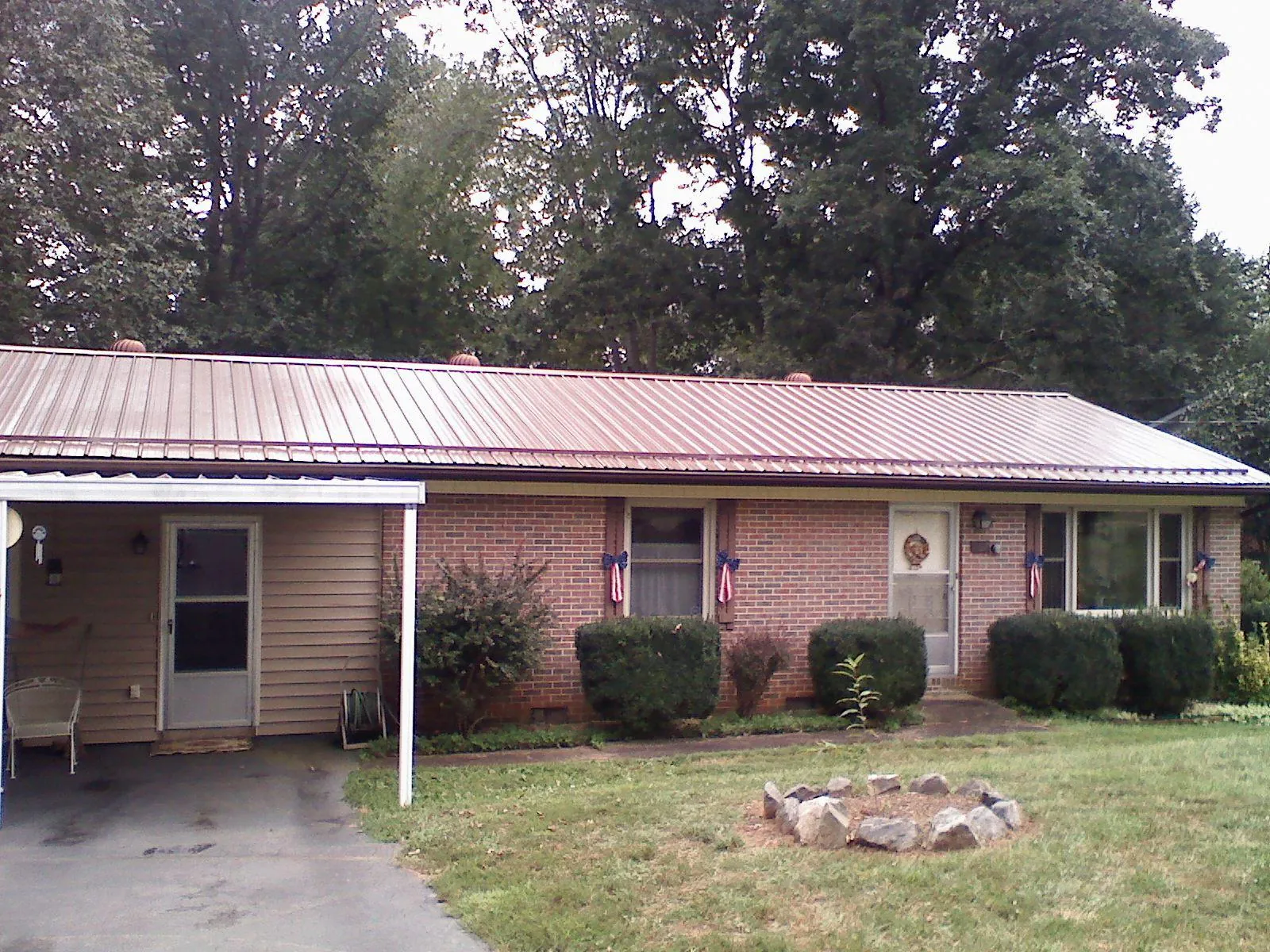 Bronze metal roof and carport on a brick ranch home — Roof Repair work by our crew in Verdi